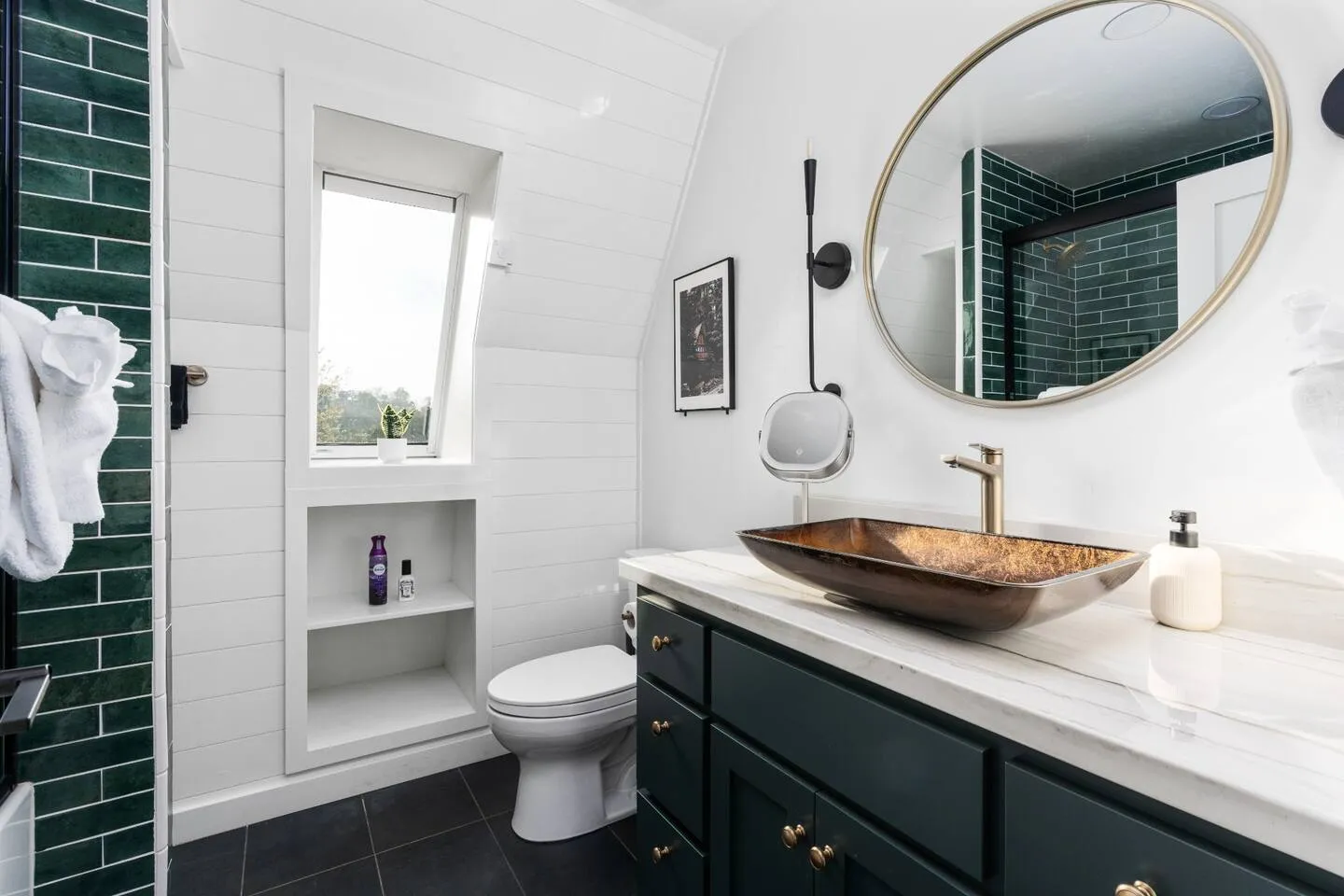 Bathroom with a deep-green tiled tub and shower, marble vanity and copper vessel sink