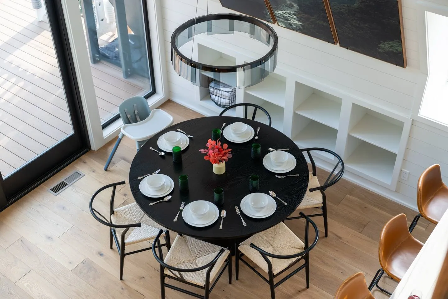 Round dining table for six under a statement chandelier